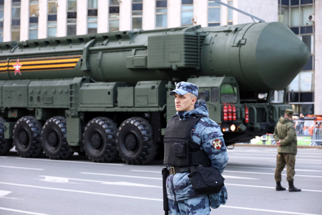 Un soldat russe se tient devant un missile ballistique thermonucléaire RS-24 Yars dans une rue de Moscou, en mai 2022.