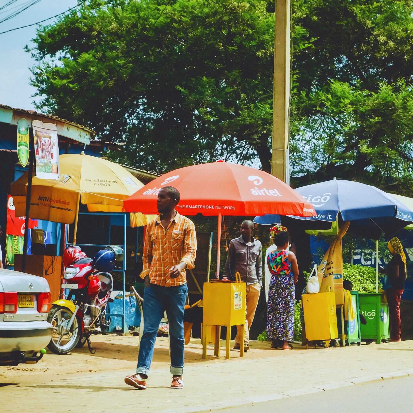 KIGALI, RWANDA - CIRCA FEBRUARY 2017: A colorful streetscape with motos, bikes and people in the outskirts of the capital city, Kigali.