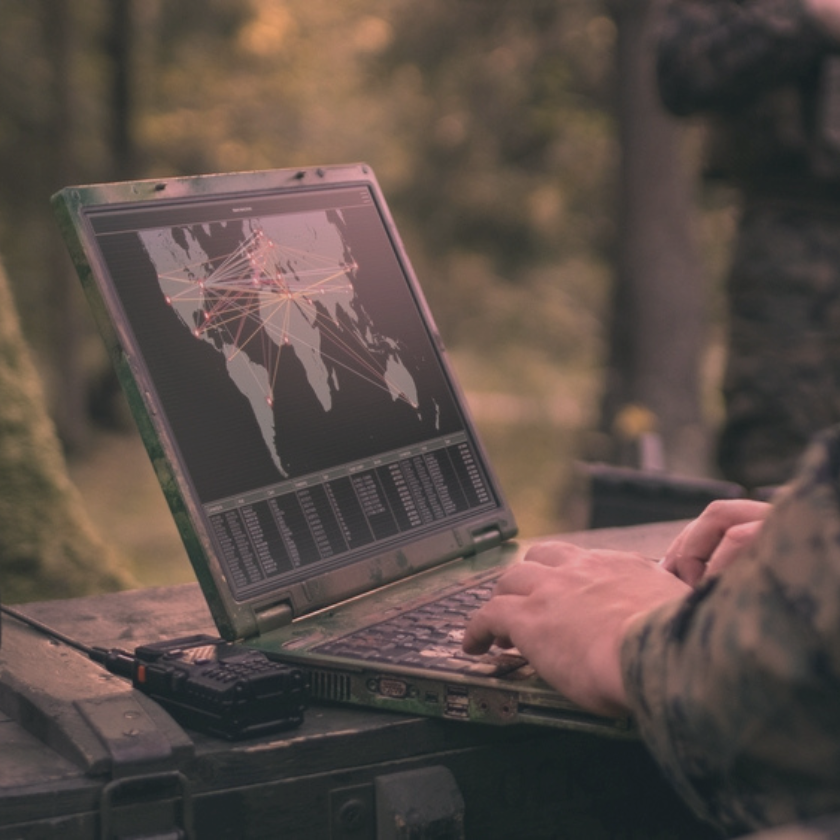  A soldier looking at a map on a laptop.