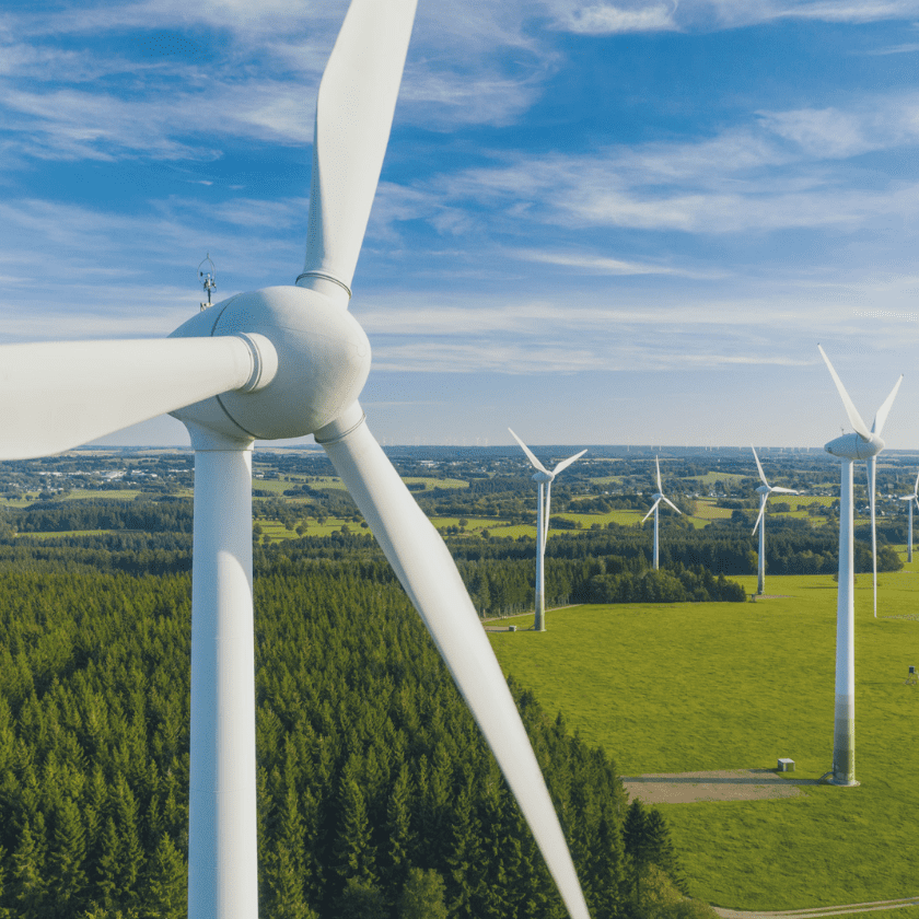 Wind turbines generating sustainable energy amidst a green field.