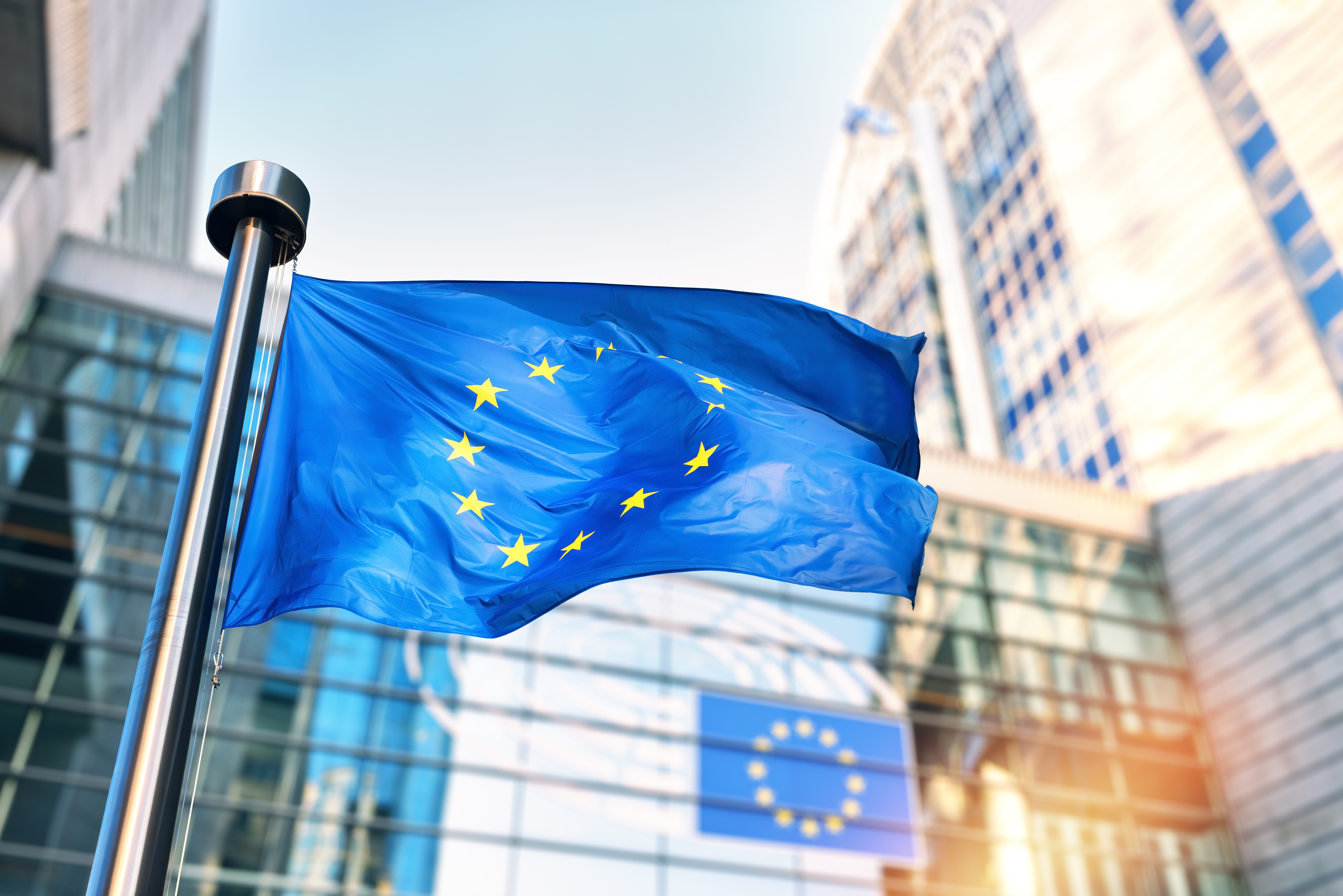 EU flag waving in front of European Parliament building. Brussels, Belgium