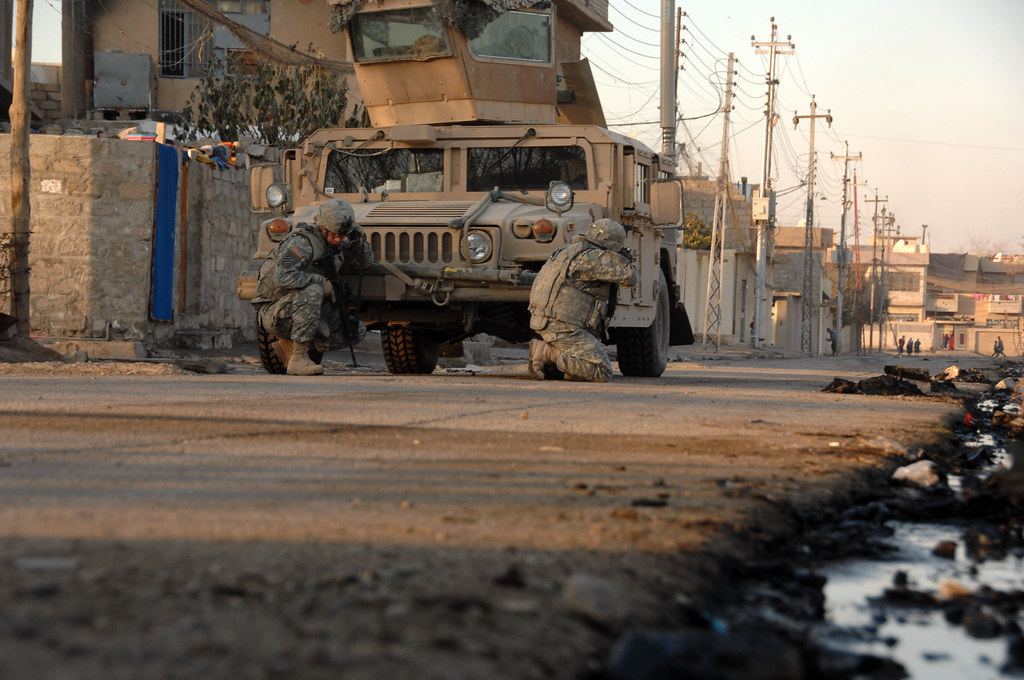 Des soldats de l'armée américaine du 3e régiment de cavalerie blindée se mettent à couvert derrière leur véhicule à Mossoul, en Irak, le 17 janvier 2008.