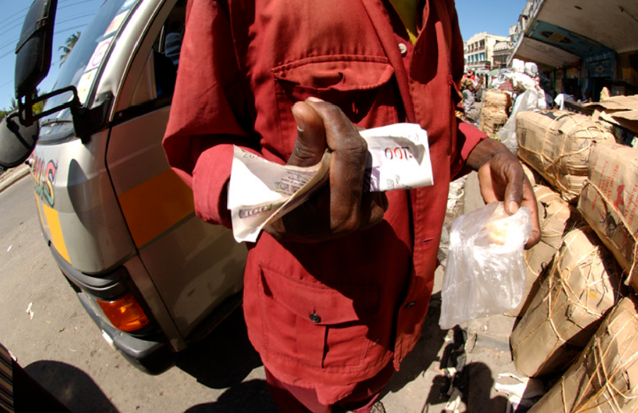 Hand holding several bills of Kenyan shilling