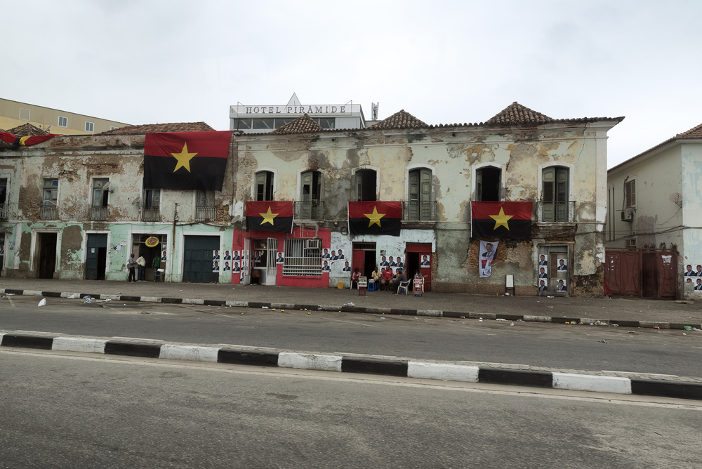 Habitants assis dans la rue le jour des élections en Angola, sous les drapeaux du Mouvement populaire de libération de l'Angola (MPLA), 23 août 2017