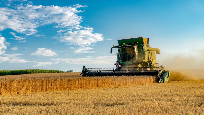 Bavaria, Germany-July 2018: View of agricultural wheat field during harvest time with industrial combine machine in working process.